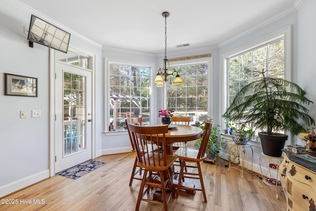 dining area featuring wood-type flooring, a notable chandelier, and ornamental molding