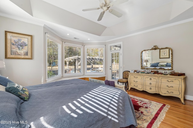 bedroom with ceiling fan, crown molding, light hardwood / wood-style flooring, and a raised ceiling