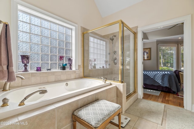 bathroom featuring tile patterned flooring, independent shower and bath, and vaulted ceiling