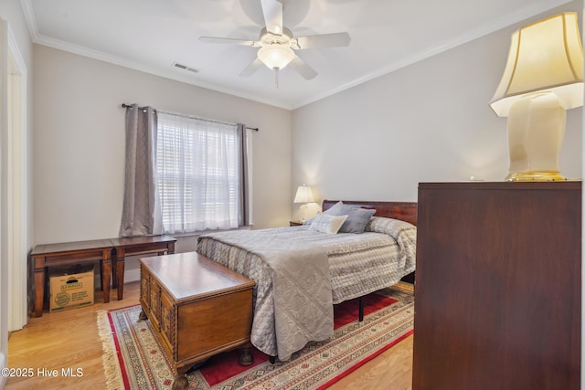 bedroom featuring ceiling fan, light hardwood / wood-style floors, and ornamental molding