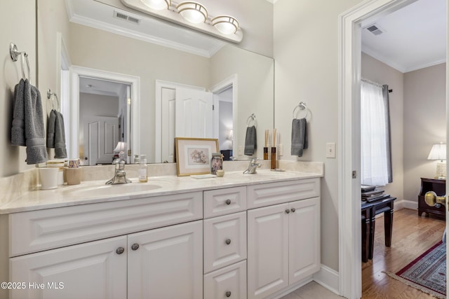 bathroom with ornamental molding, hardwood / wood-style floors, and vanity