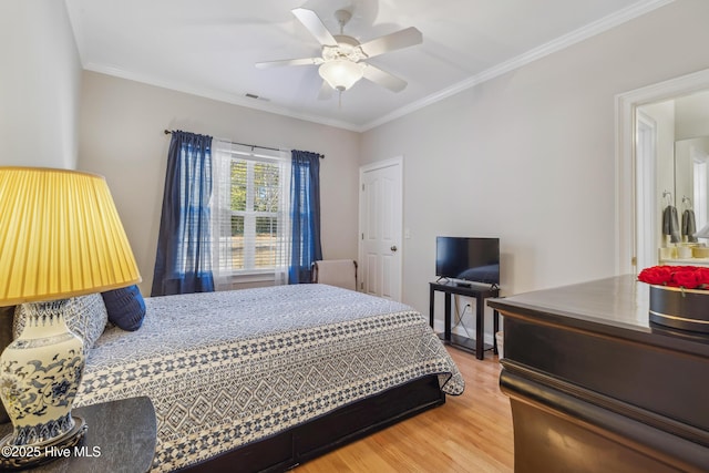 bedroom featuring ceiling fan, wood-type flooring, and ornamental molding