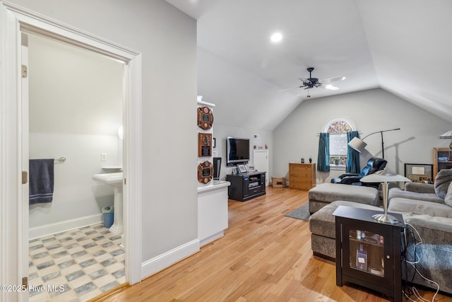 living room featuring ceiling fan, vaulted ceiling, and light wood-type flooring