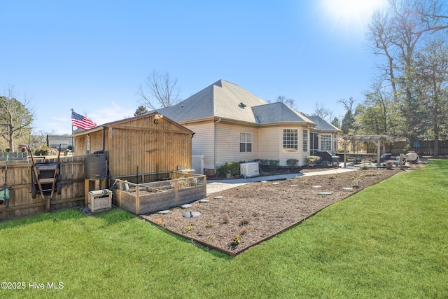 back of house with a yard and a pergola