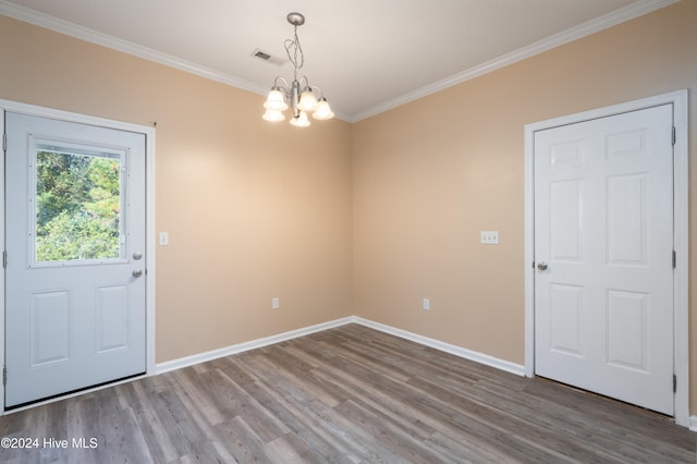 unfurnished dining area with hardwood / wood-style floors, a notable chandelier, and crown molding