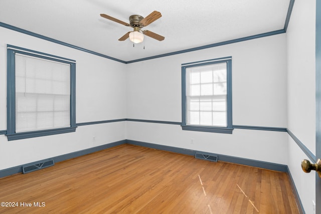 empty room with ornamental molding, hardwood / wood-style floors, a textured ceiling, and ceiling fan