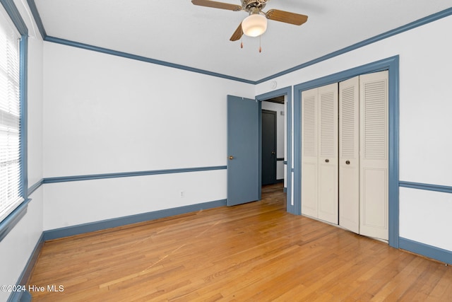 unfurnished bedroom with a closet, ceiling fan, light hardwood / wood-style floors, and crown molding