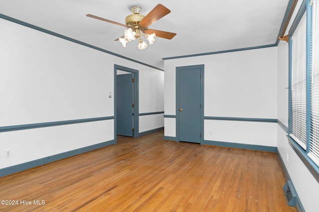 spare room featuring light hardwood / wood-style floors, ceiling fan, and ornamental molding