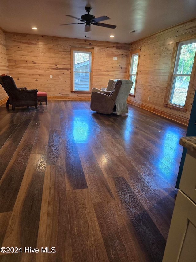 unfurnished room featuring ceiling fan, dark hardwood / wood-style floors, and wooden walls