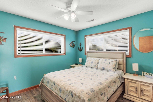 bedroom with ceiling fan and dark hardwood / wood-style floors