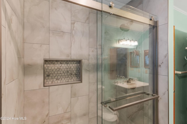 bathroom with crown molding and a shower with shower door