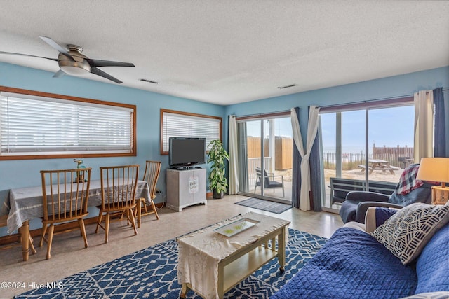 living room with a textured ceiling and ceiling fan