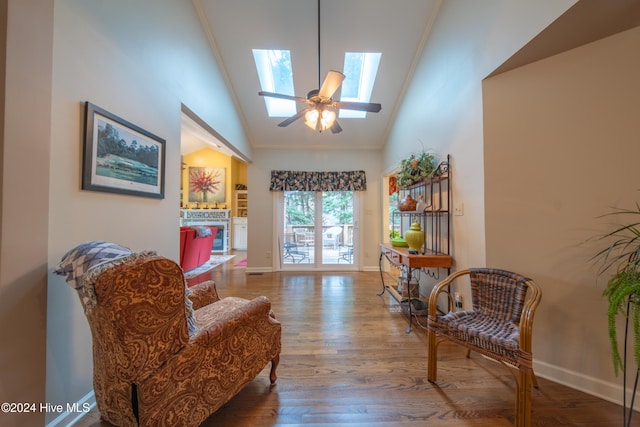 sitting room featuring a skylight, hardwood / wood-style flooring, crown molding, and ceiling fan