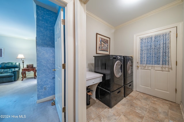 clothes washing area with light carpet, crown molding, and washing machine and clothes dryer