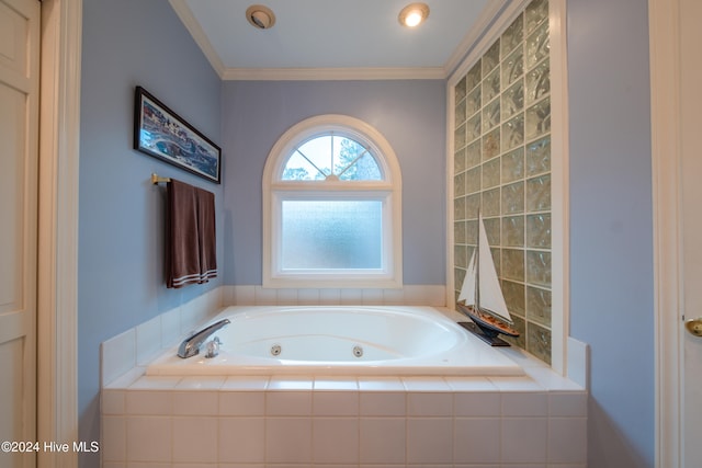 bathroom featuring ornamental molding and tiled tub