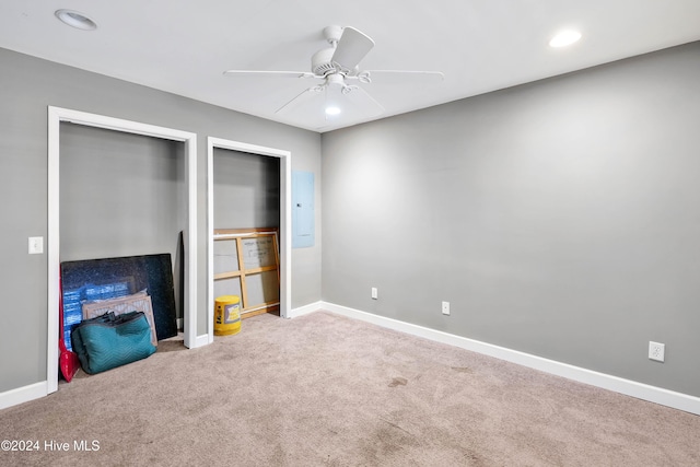 unfurnished living room with carpet flooring, electric panel, and ceiling fan