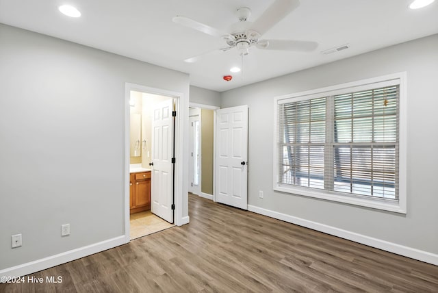 unfurnished bedroom with ensuite bathroom, light hardwood / wood-style flooring, and ceiling fan