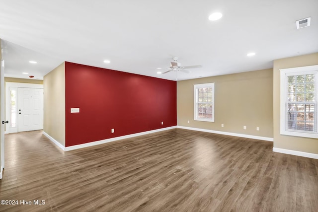 empty room with ceiling fan and dark wood-type flooring