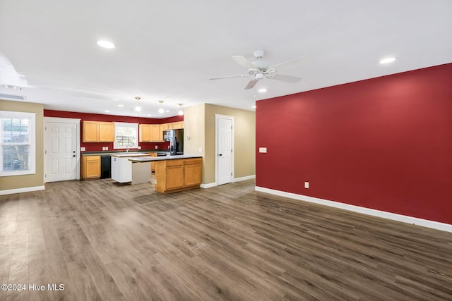 kitchen with dark hardwood / wood-style flooring, ceiling fan, sink, black appliances, and a center island