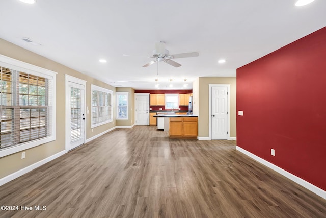 unfurnished living room featuring ceiling fan and dark wood-type flooring