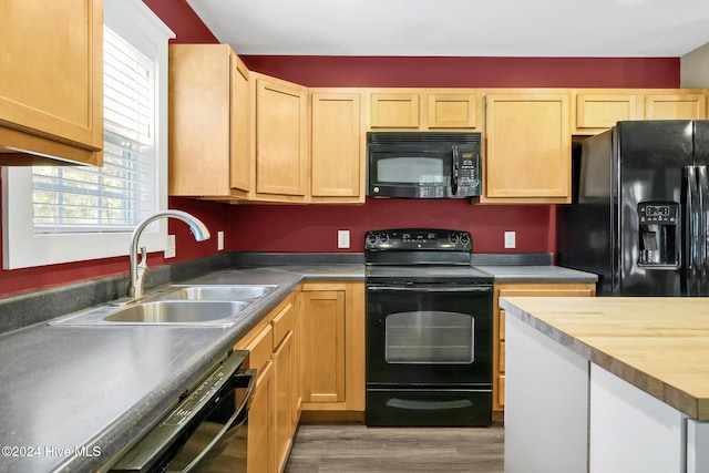 kitchen with wooden counters, wood-type flooring, sink, and black appliances