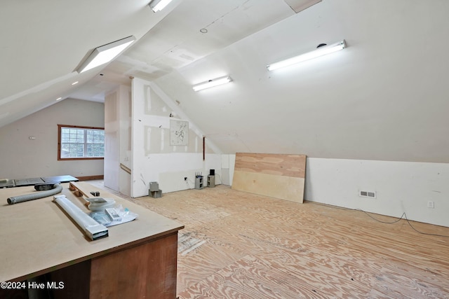 additional living space with vaulted ceiling with skylight