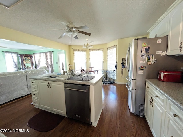 kitchen with stainless steel appliances, dark wood-type flooring, a center island, a textured ceiling, and white cabinetry