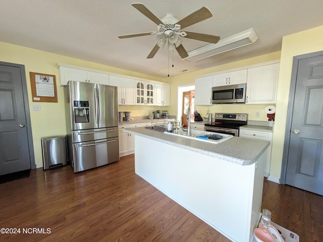 kitchen featuring stainless steel appliances, sink, a kitchen island with sink, white cabinets, and dark hardwood / wood-style flooring