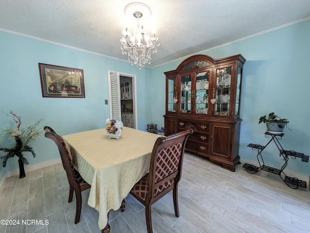 dining space featuring ornamental molding, light hardwood / wood-style floors, a textured ceiling, and a chandelier