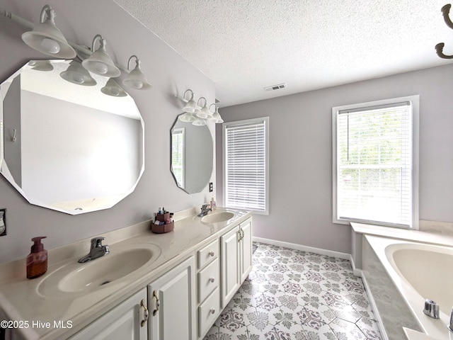 117 Longwood Dr, Stella, NC 28582 - bathroom with a textured ceiling, a bath, double vanity, and baseboards