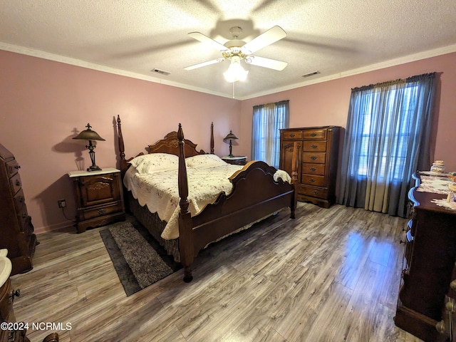 bedroom with ornamental molding, multiple windows, wood-type flooring, and ceiling fan