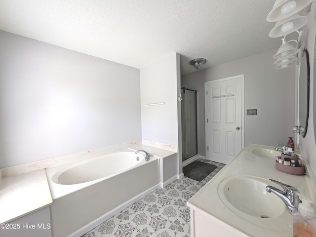 117 Longwood Dr, Stella, NC 28582 - bathroom featuring a garden tub, a shower stall, a textured ceiling, double vanity, and tile patterned floors