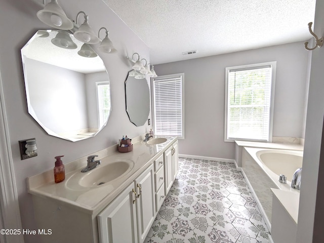 117 Longwood Dr, Stella, NC 28582 - full bath with healthy amount of natural light, a textured ceiling, double vanity, a bath, and baseboards