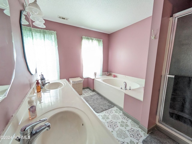 bathroom with vanity, a textured ceiling, and shower with separate bathtub