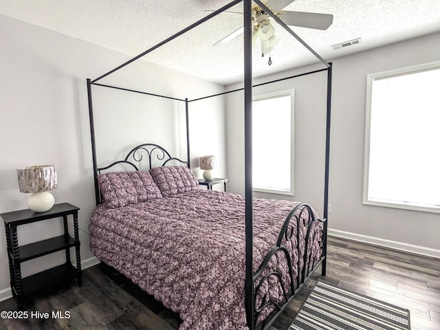 117 Longwood Dr, Stella, NC 28582 - bedroom with dark wood-style floors, a textured ceiling, baseboards, and a ceiling fan
