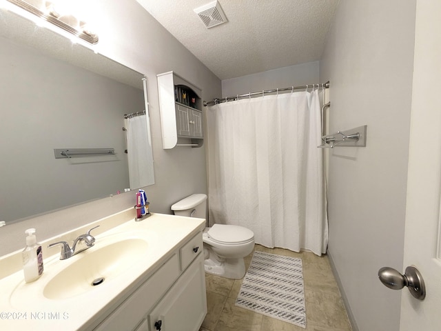 bathroom featuring tile patterned floors, toilet, a textured ceiling, vanity, and a shower with shower curtain