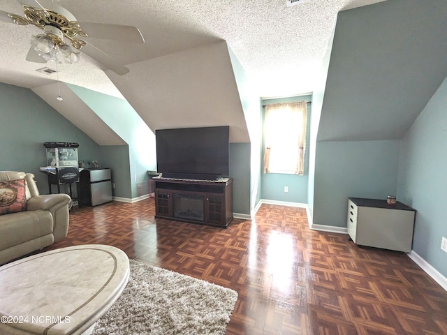 living room featuring dark parquet flooring, lofted ceiling, a textured ceiling, and ceiling fan