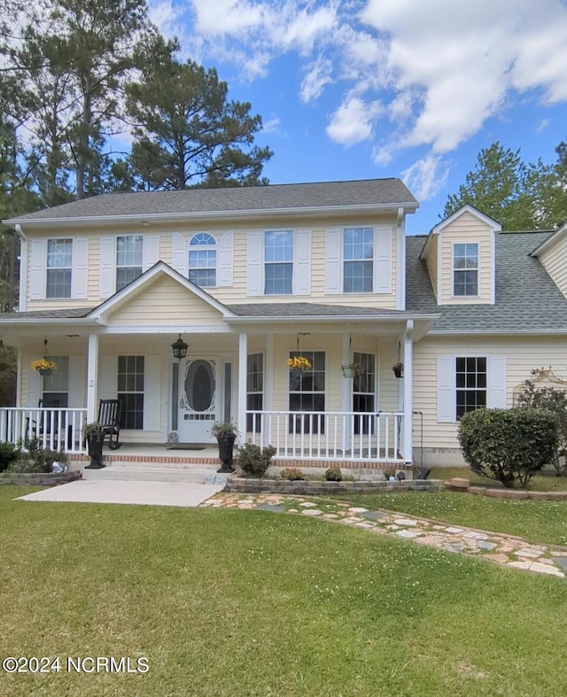 view of front facade with a front yard and covered porch