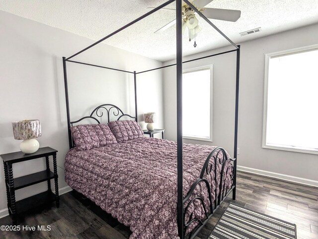 117 Longwood Dr, Stella, NC 28582 - bedroom with dark wood-style floors, a textured ceiling, baseboards, and a ceiling fan