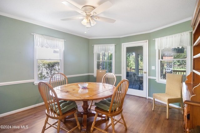 dining area with ceiling fan, a healthy amount of sunlight, dark hardwood / wood-style flooring, and ornamental molding