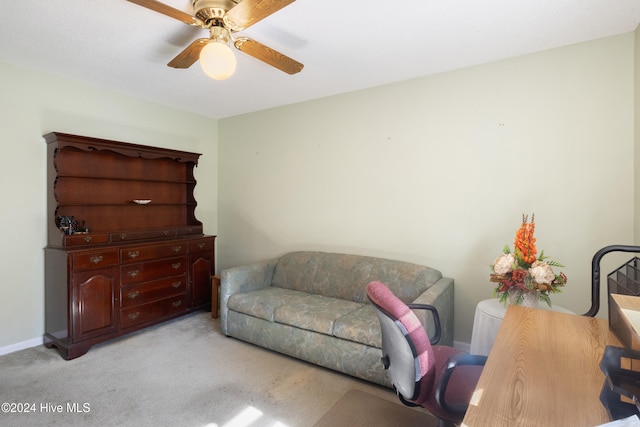 living area featuring light carpet and ceiling fan