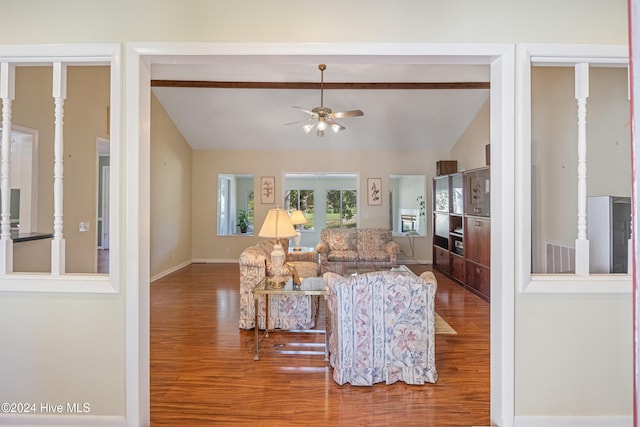 living room with vaulted ceiling with beams, ceiling fan, and wood-type flooring