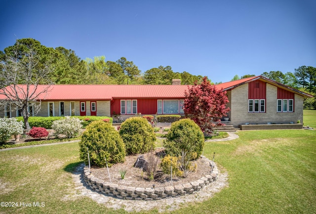 view of front of house with brick siding, a front lawn, and a chimney