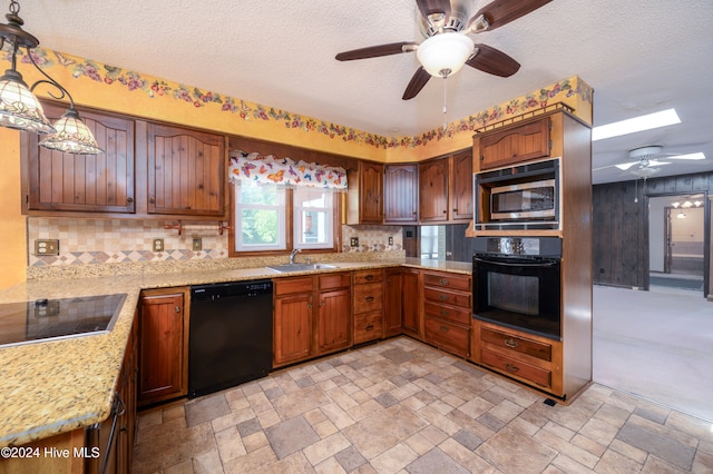 kitchen featuring decorative backsplash, a textured ceiling, sink, black appliances, and hanging light fixtures