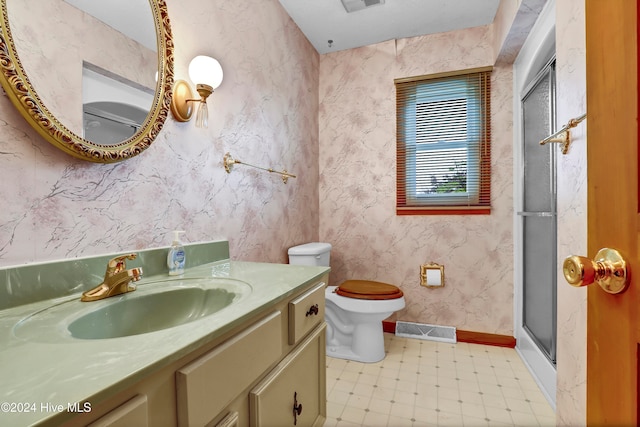 bathroom featuring an enclosed shower, vanity, and toilet