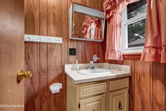 bathroom featuring vanity and wooden walls