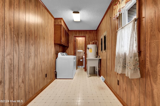 washroom with wood walls, cabinets, independent washer and dryer, and water heater