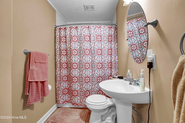 bathroom featuring walk in shower, a textured ceiling, and toilet