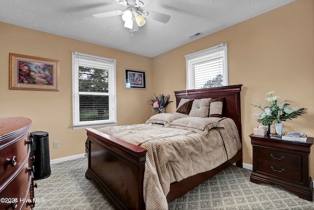 bedroom featuring a textured ceiling, ceiling fan, and light carpet