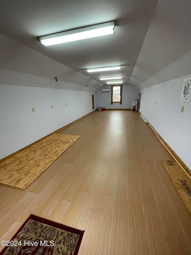 spare room featuring hardwood / wood-style floors and vaulted ceiling